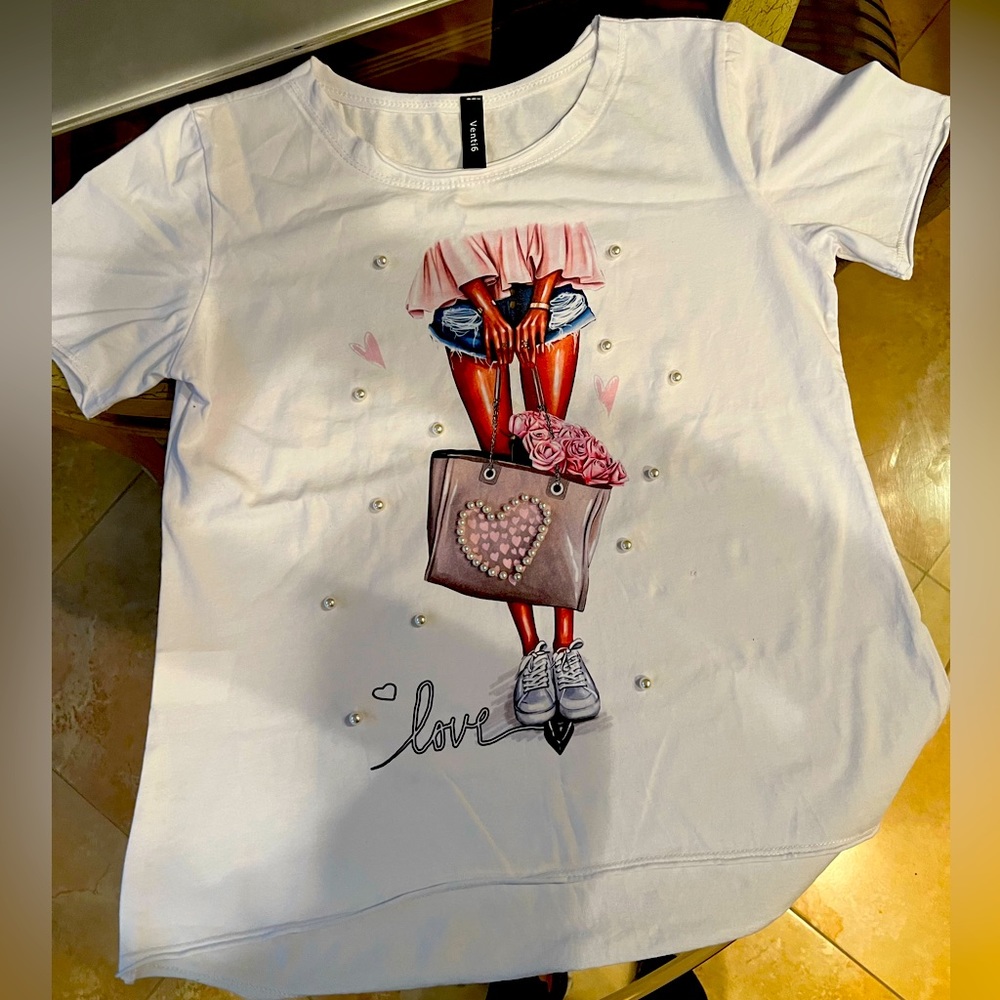 S/s top with design of shopping girl and bag. Pearl attachments and word "love"